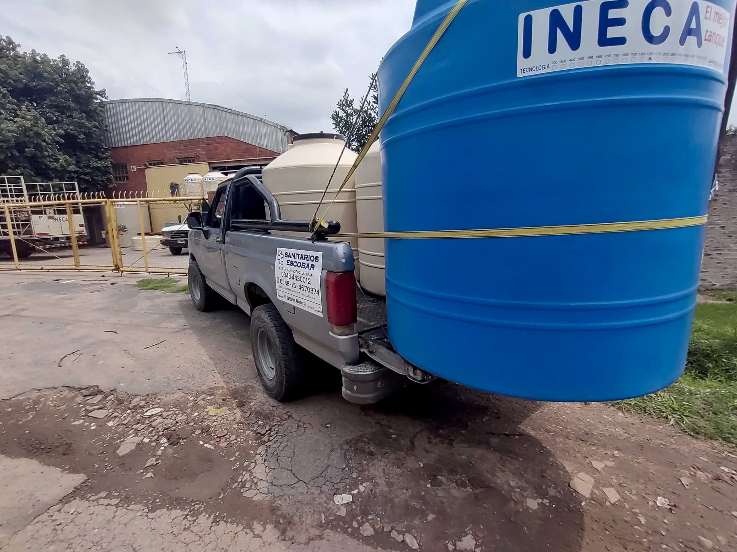 Camioneta de SANITARIOS ESCOBAR cargada con tanques de agua para una entrega