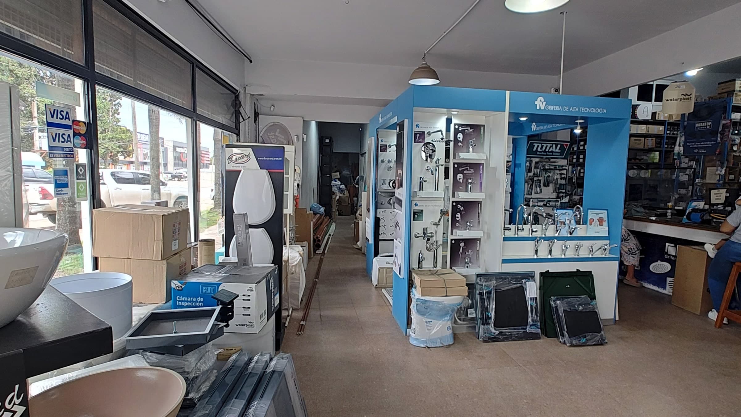 Interior del local de SANITARIOS ESCOBAR, con la exhibición de griferías y el mostrador al fondo