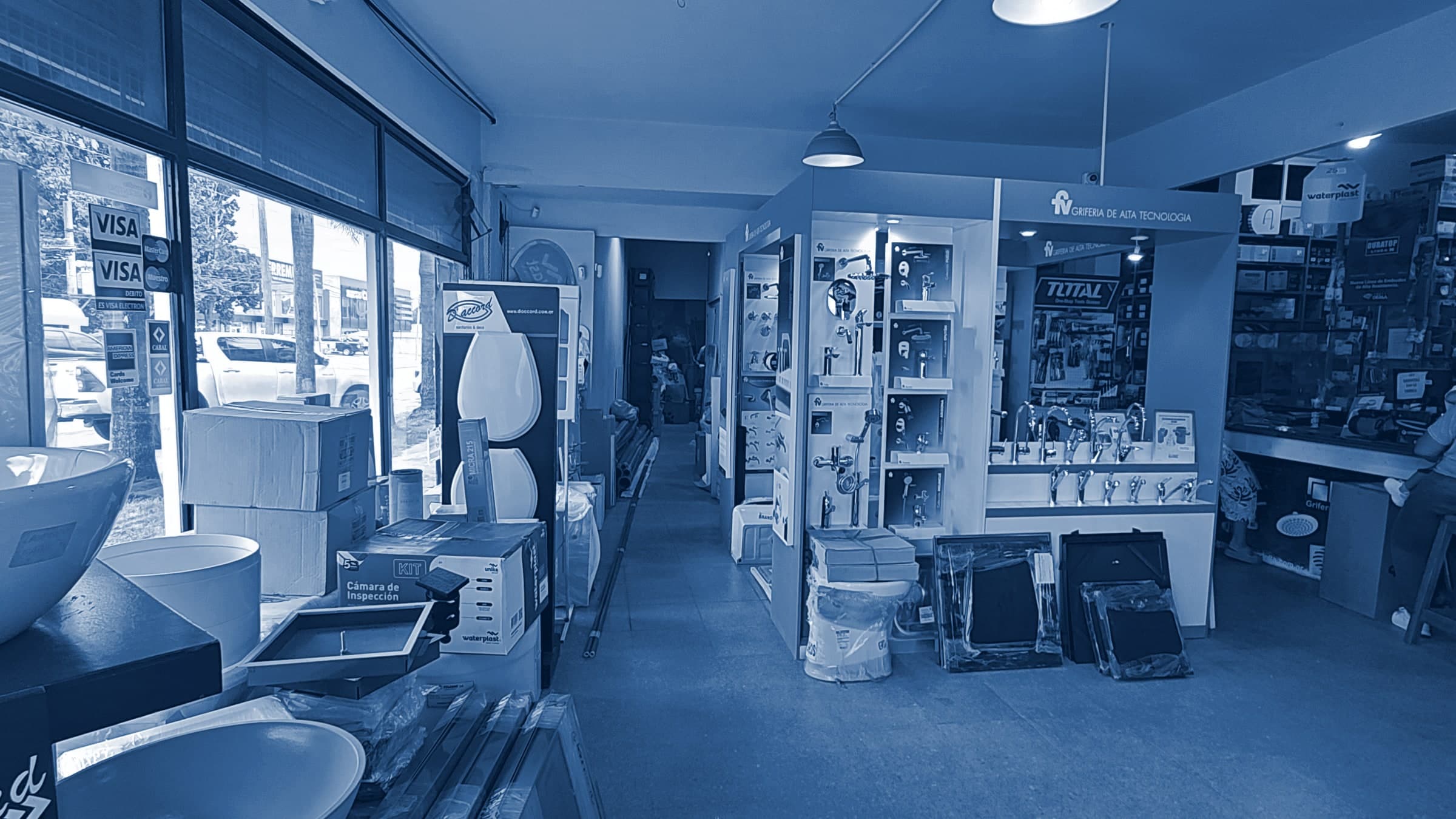 Interior del local de SANITARIOS ESCOBAR, con la exhibición de griferías y el mostrador al fondo